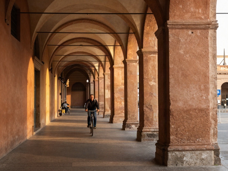 A covered portico walkway in Bologna at golden hour